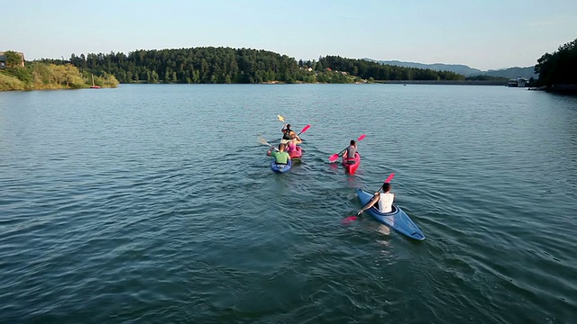 年轻的男孩和女孩在湖中划独木舟视频素材