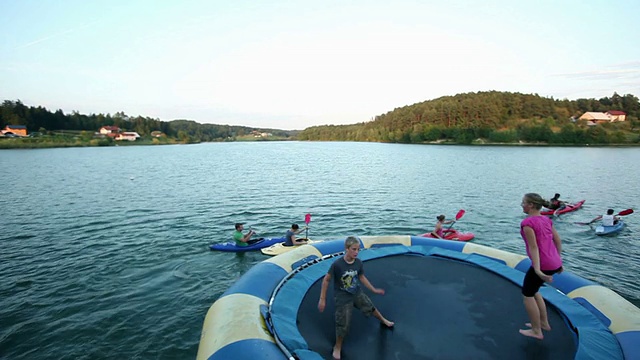 HD CRANE:年轻人在湖中慢慢划独木舟视频素材