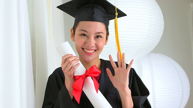 亚洲毕业生挥舞着文凭视频素材