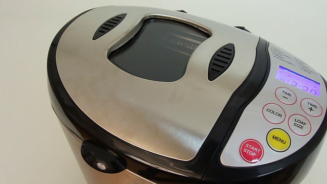 手按面包机面板上的按钮进行烘烤视频素材
