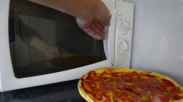 辣香肠披萨在微波炉中缓慢旋转。视频素材