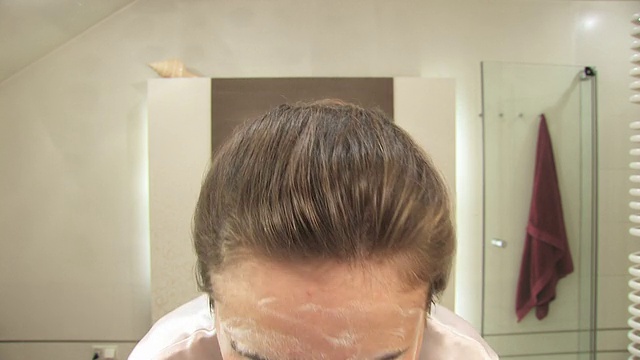 美丽的金发女孩在洗脸视频素材