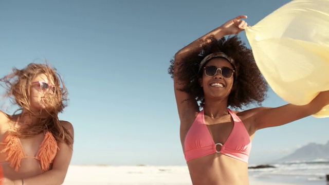 一个非洲女孩在阳光明媚的海滩上放飞一块布视频素材
