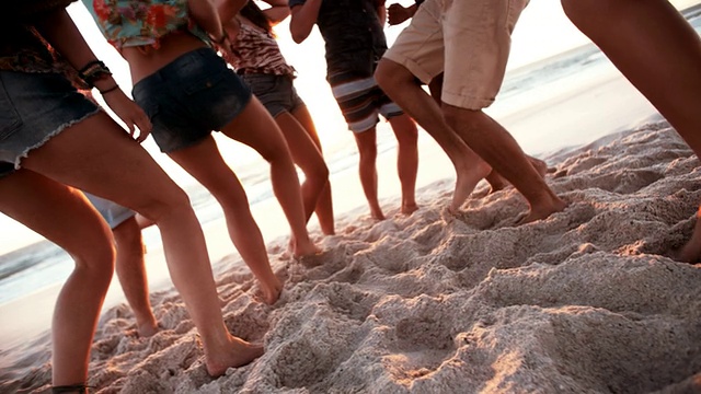 夕阳西下，青春的双腿在沙滩上跳舞视频素材