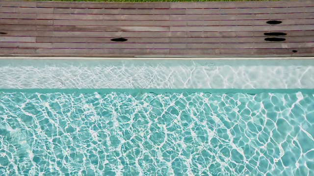 游泳池里闪亮的蓝色海水和木制的小路。视频素材