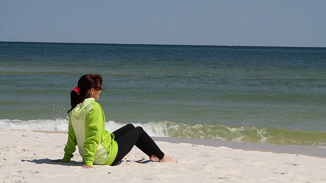 女人坐在海滩上视频素材