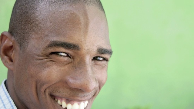 一个快乐的年轻黑人看着镜头，微笑着视频下载