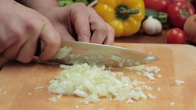 厨师用刀切洋葱，跟踪拍摄视频素材