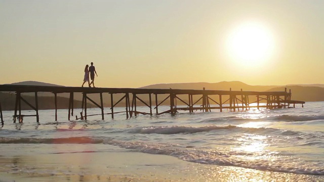 年轻夫妇剪影Wwalking在码头浪漫概念HD视频下载