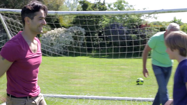 多代男性家庭在花园里踢足球视频素材