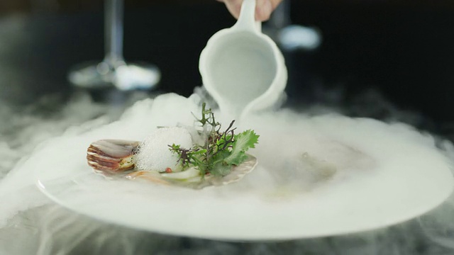 厨师在豪华餐厅用干冰装饰扇贝。视频素材