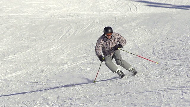 慢动作:滑雪者在被雪覆盖的斜坡上雕刻视频素材