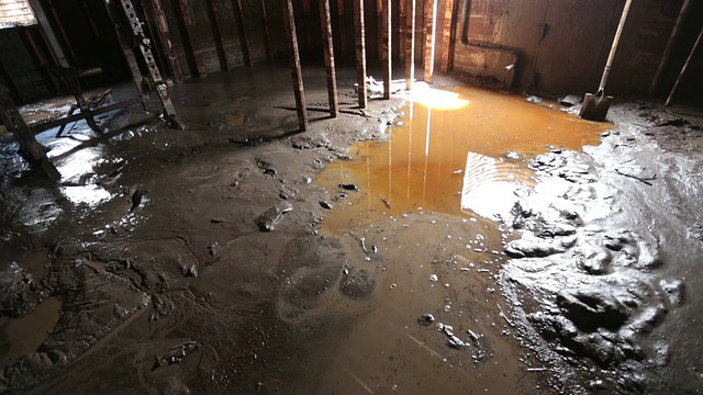 被淹的地下室里的人在厚厚的泥浆中行走视频素材