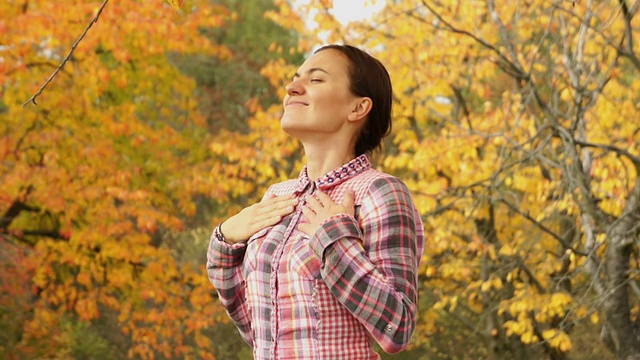 美丽的女孩呼吸在秋天的公园视频素材