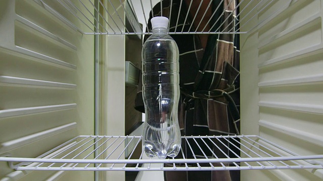 男子从空冰箱里拿出一瓶水视频素材