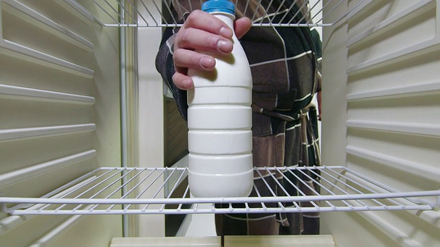 男人从冰箱里拿出奶瓶视频素材