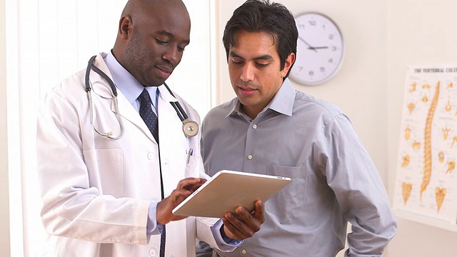 非裔美国医生用平板电脑治疗西班牙病人视频素材