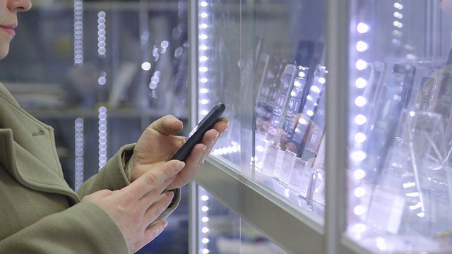 顾客在电子商店选择智能手机视频素材