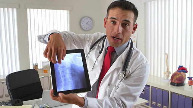西班牙裔医生用平板电脑显示颈部x光片视频素材