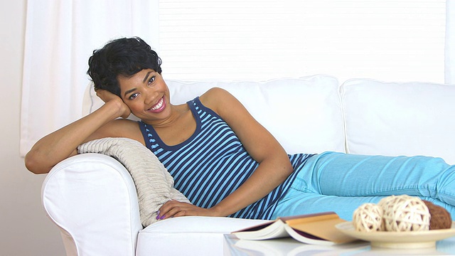沙发上微笑的非裔美国妇女视频素材