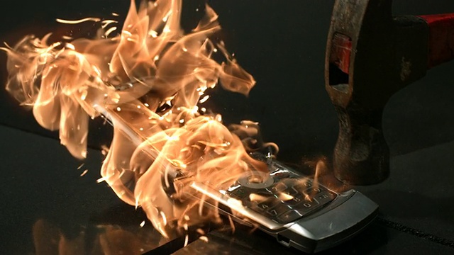 用火和锤子摧毁了一个旧手机视频素材