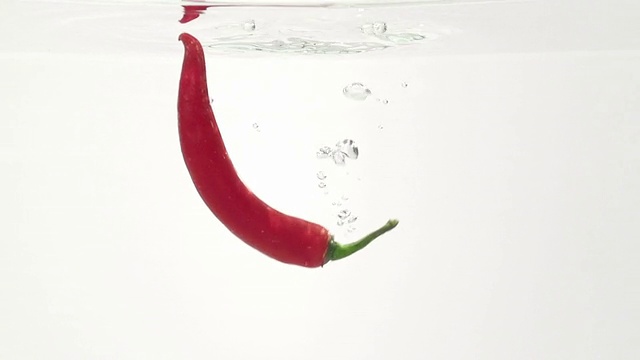 苦辣椒在水中。慢动作视频素材