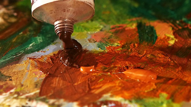 画家在调色板上挤出棕色的油彩，特写慢动作视频下载