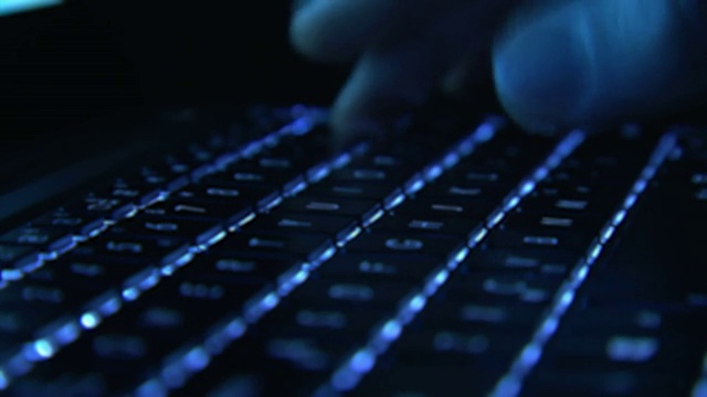 男性的手在发光的键盘上打字视频素材