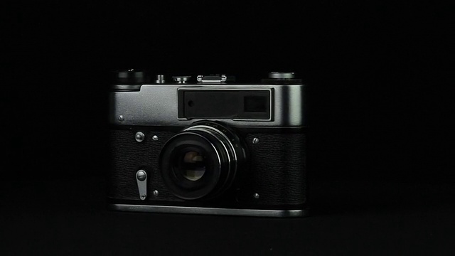 旧照片相机在黑色背景循环上旋转视频素材