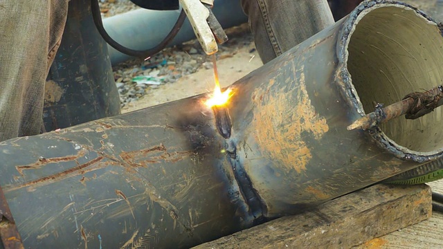 焊工在现场使用电弧焊管金属。视频下载