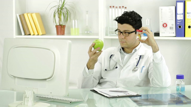 年轻医生选择药片而不是水果药物概念视频素材