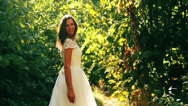 美丽的年轻女子新娘在森林微笑着装自然视频素材