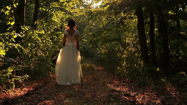 年轻女子在复古婚纱行走森林背景视频下载