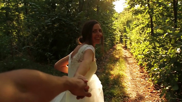 浪漫婚礼概念:新娘牵手森林漫步视频素材