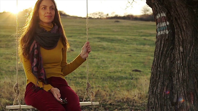 年轻快乐的女人在自然中发短信日落的颜色视频下载