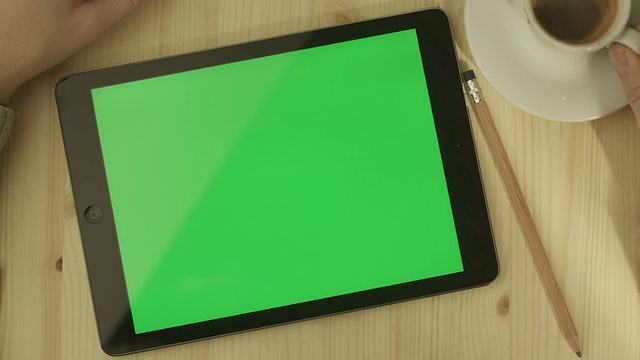 桌上放着绿色屏幕的平板电脑视频下载