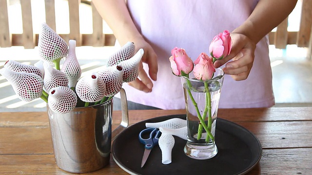 女人把刚摘下来的粉色玫瑰浸泡在花瓶里视频素材
