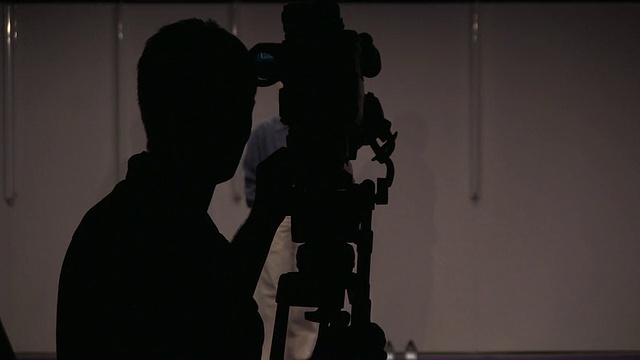 摄影棚拍摄的年轻人用摄像机捕捉记者视频下载