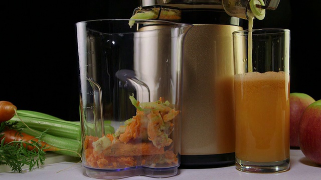 多莉:用冷榨榨汁机从胡萝卜、苹果、芹菜中提取鲜汁的工艺视频素材