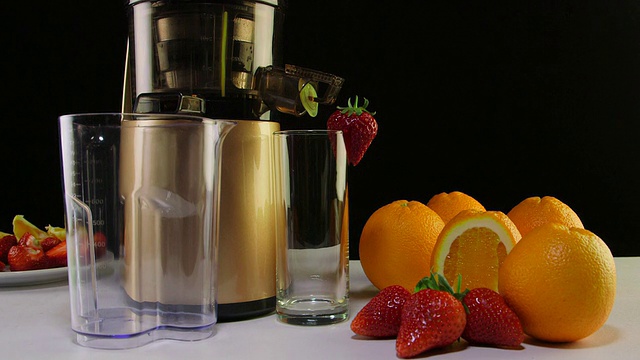 多莉:冷压榨汁机，用于从草莓和橙子中榨取水果和浆果汁视频素材