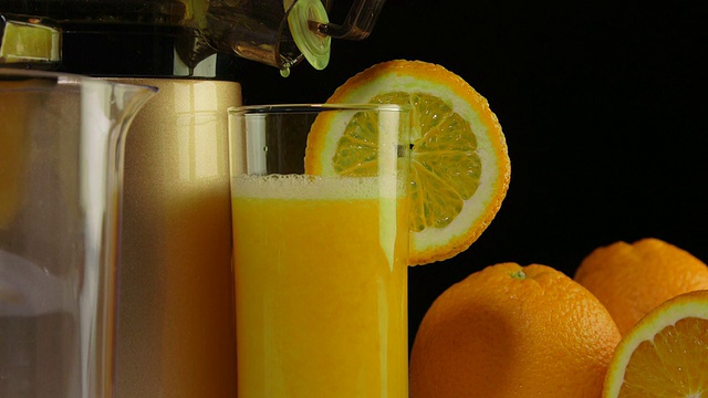 多莉:一杯新鲜榨出的橙汁，配上咀嚼榨汁机视频素材