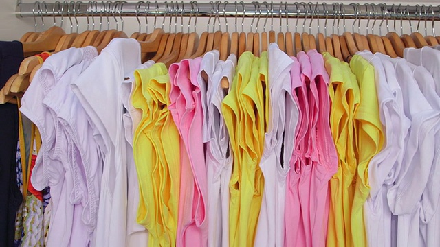 多莉:服装店挂在衣架上的五颜六色的t恤视频素材