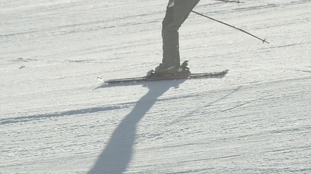 特写:在阳光明媚的冬天，滑雪者沿着斜坡滑雪视频素材