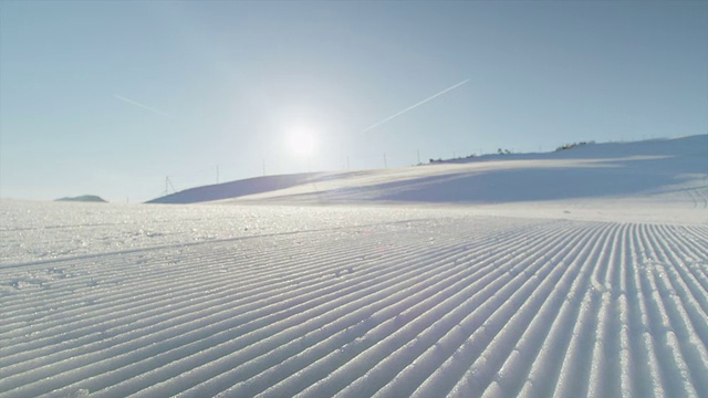 近距离观察:在阳光明媚的滑雪胜地完美整理雪道视频素材