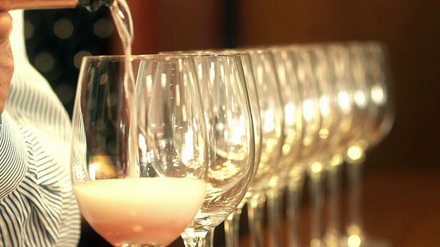 侍酒师将玫瑰葡萄酒倒入一排水晶酒杯中视频下载