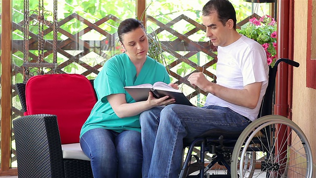 理疗师向坐轮椅的年轻人解释运动视频素材