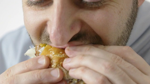 饥饿的人吃着汉堡:减肥、垃圾食品、快餐视频素材