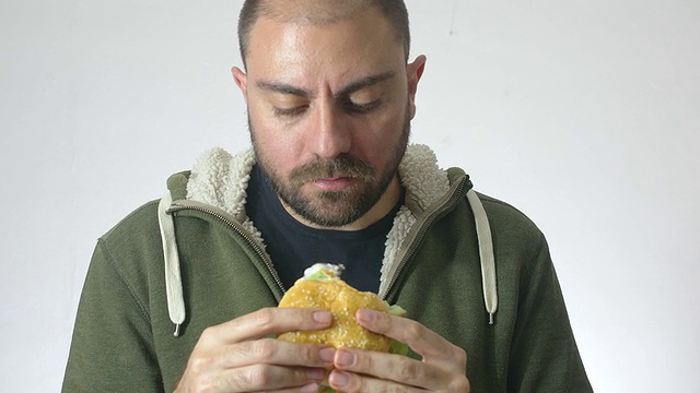 一个人在吃一个XXL汉堡:减肥，垃圾食品，快餐视频素材