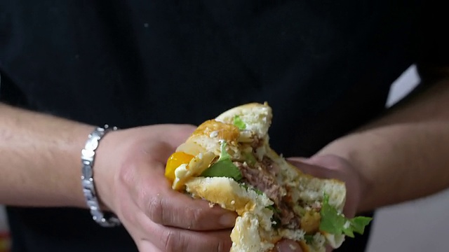 一个饥饿的人手里拿着一个大汉堡视频素材