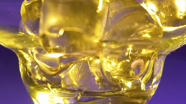 酒保将冰块倒入玻璃杯，倒入酒精液体，近距离，慢动作视频素材